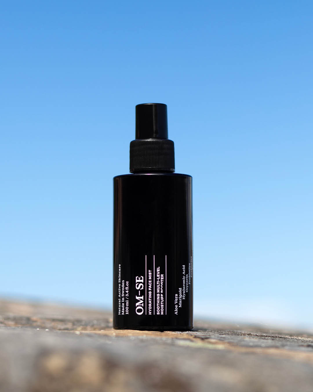 OM-SE Hydrating Face Mist outdoor with blue sky in background