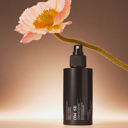 OM-SE Hydrating Face Mist bottle with a flower on a gradient background